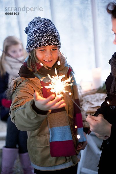 Mädchen in Winterkleidung berühren im Gewächshaus