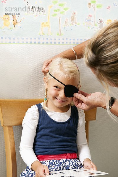 Frau Mädchen Auge  Sehkraft Steuerelement Augenklappe anziehen