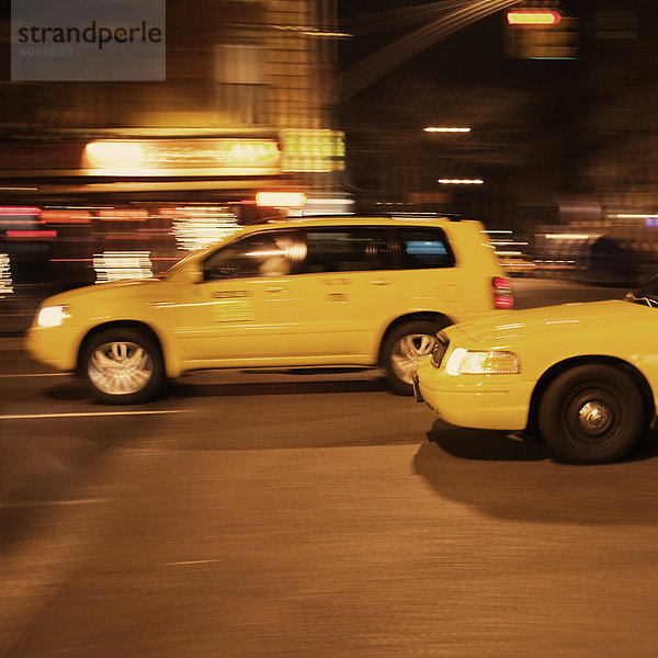 Taxis auf der Straße bei Nacht  Bewegungsunschärfe