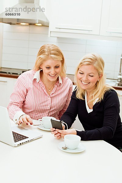 Zwei junge Frauen mit Laptop in der Küche