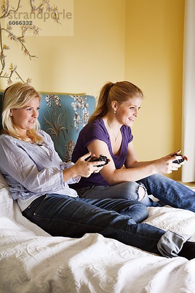 Zwei junge Frauen Video-Spiel im Schlafzimmer