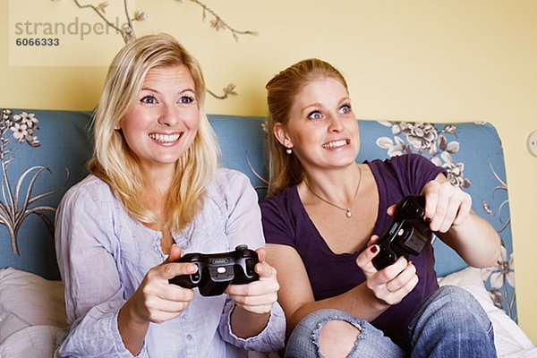 Zwei junge Frauen Video-Spiel im Schlafzimmer