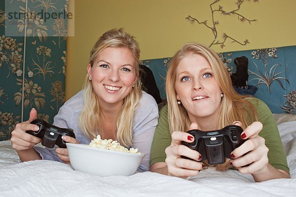 Zwei junge Frauen Video-Spiel im Schlafzimmer