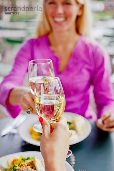 Zwei Frauen Toasten Wein im Café im freien