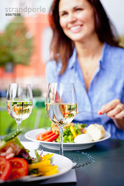 Frau essen Salat im Café im freien