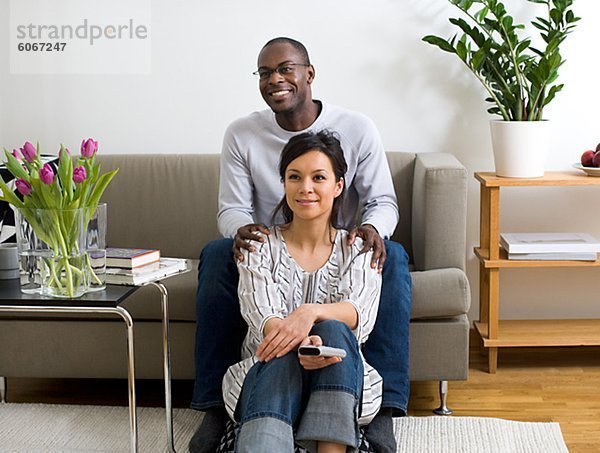 Porträt des Paares im Wohnzimmer sitzen und Fernsehen