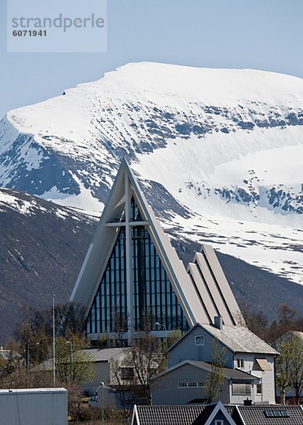 Kirche mit schneebedeckten Bergen im Hintergrund