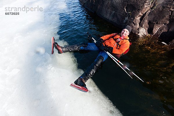 Man Eislaufen und balancing über Loch im Eis