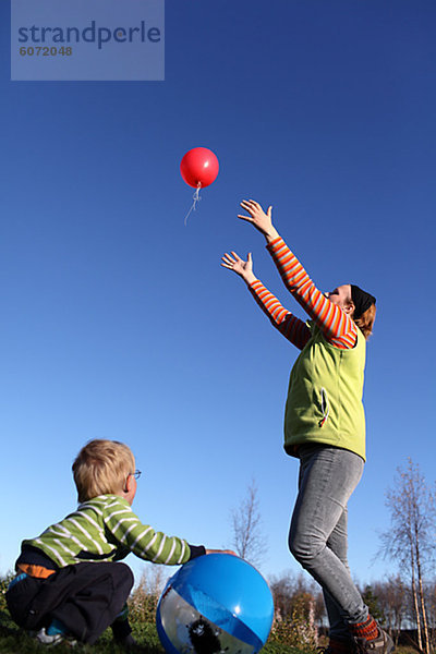 Mutter und Sohn spielen mit Luftballons