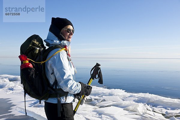 Frau trägt Rucksack stehen auf Schnee See