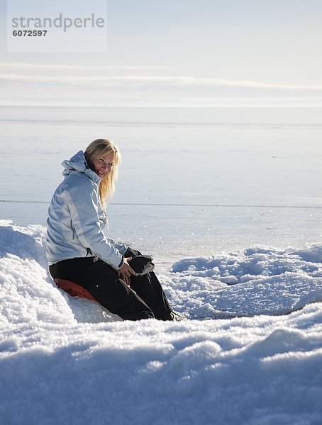 Frau sitzt auf Schnee  Porträt