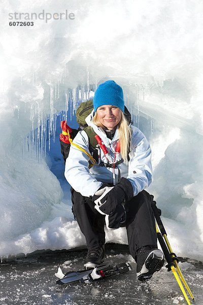 Frau sitzt auf Eis  Lächeln  Porträt