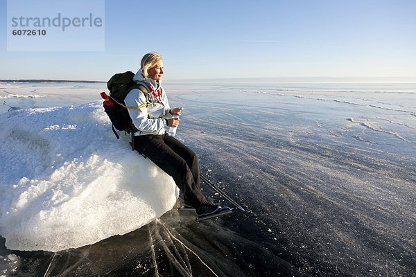 Frau sitzt auf dem Eis