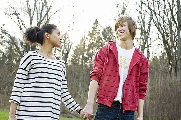 Teenage paar stehend mit Hand in Hand