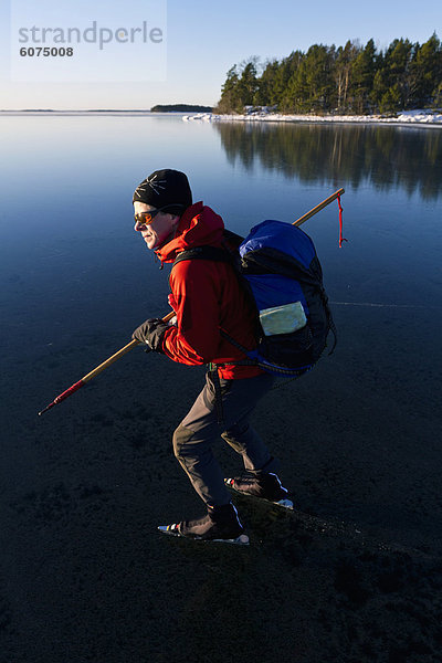 Man Eislaufen am zugefrorenen See