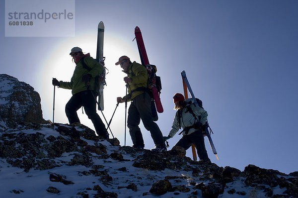 hoch  oben  Felsen  Silhouette  Gerät  Ski  spritzen  befestigen  3  Skifahrer  klettern  Heiligenschein  Hang  Sonne
