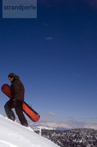 hoch  oben  Berg  Mann  Snowboard  gehen  Schnee  unbewohnte  entlegene Gegend  jung