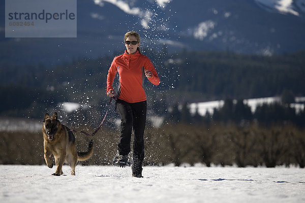 nahe  Frau  rennen  Hund  jung  Schneeschuh  deutsch  Kapuze  Oregon  Schafhirte  Schnee