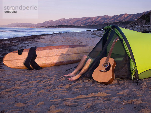 liegend liegen liegt liegendes liegender liegende daliegen Mann Strand warten camping Zelt Gitarre jung Brandung