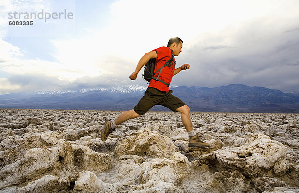 Rucksack Nationalpark Anschnitt Mann rennen jung Death Valley Nationalpark Golfsport Golf Kurs