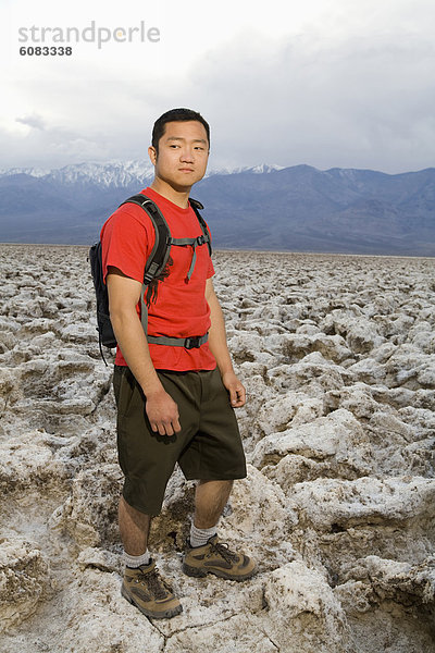 Rucksack Nationalpark Anschnitt stehend Mann jung Death Valley Nationalpark Golfsport Golf Kurs