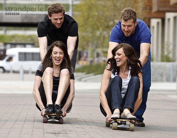 Frau  Mann  lachen  schieben  Weg  Großstadt  2  jung  Skateboard