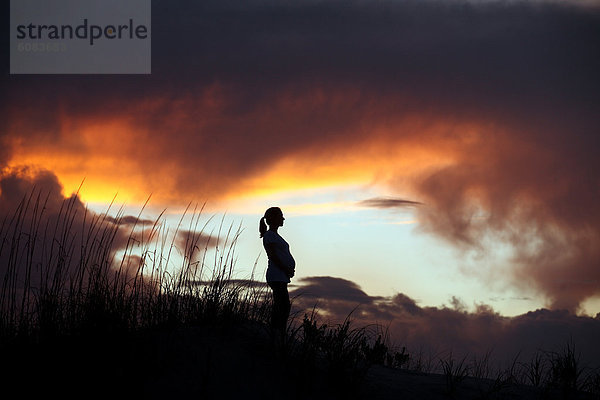 Farbaufnahme  Farbe  stehend  Frau  Sonnenuntergang  Silhouette  Hügel  Schwangerschaft  Wiese