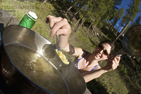 Abendessen  Frau  Boden  Fußboden  Fußböden  camping  kochen  jung  Makkaroni