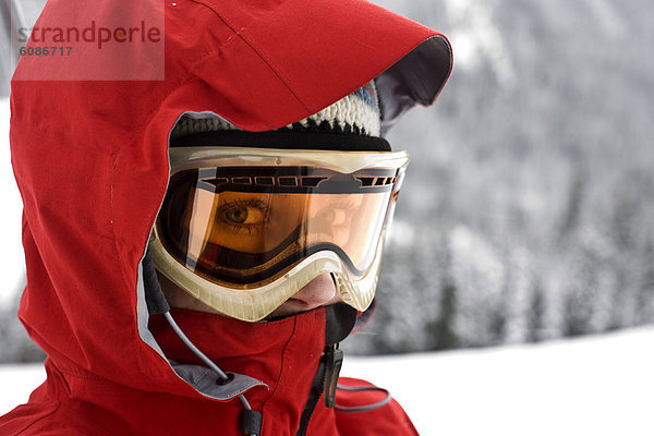 hoch  oben  nahe  Portrait  Frau  Skibrille  sehen  Schutzbrille  Mütze  Mantel  Ski  rot  Blick in die Kamera  Kleidung  gerade