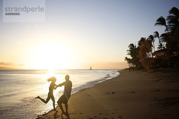 Fröhlichkeit  Strand  Sonnenuntergang  tanzen  Spiel  jung  Hawaii  Maui  rechts