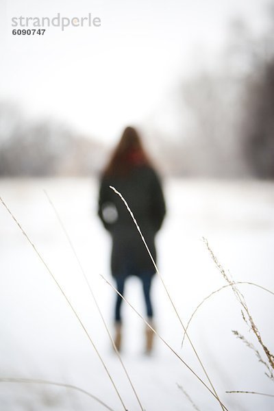 Frau  Winter  Tag  gehen  Schnee  Feld  Fokus auf den Vordergrund  Fokus auf dem Vordergrund  Gras  Colorado  gefroren  Bewölkung  bewölkt  bedeckt