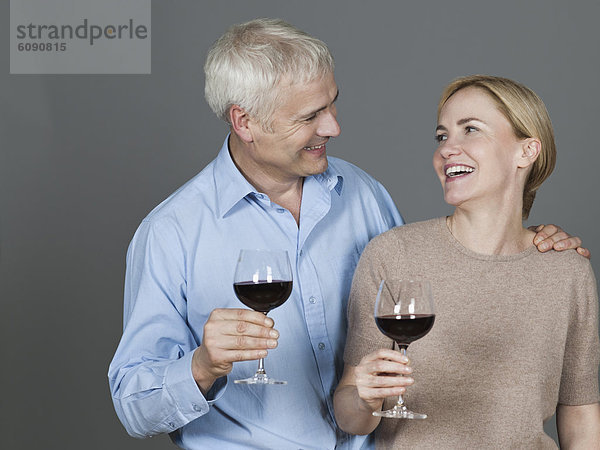 Erwachsenes Paar mit Wein  lächelnd