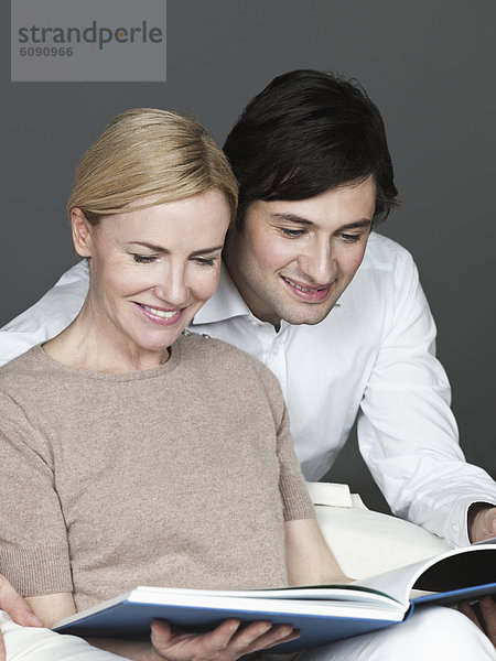 Mann und Frau lesen Buch  lächelnd