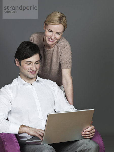Mann und Frau mit Laptop  lächelnd