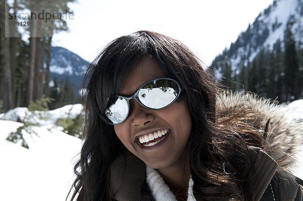 Außenaufnahme  Frau  lächeln  amerikanisch  Blick in die Kamera  jung  freie Natur  Schnee