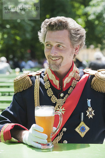 Deutschland  Mann als König Ludwig von Bayern mit Bierkrug  lächelnd
