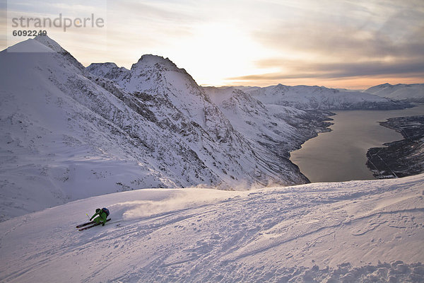 Norway  Lyngen  Skier skiing downhill at sunset