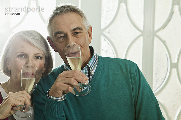 Deutschland  Berlin  Seniorenpaar trinkt Champagner  Portrait