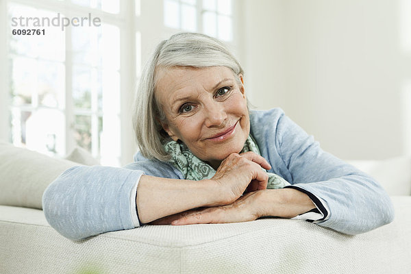 Seniorin auf Couch  lächelnd  Portrait