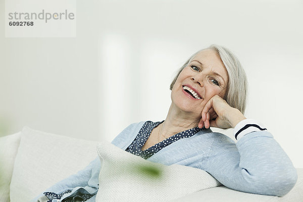 Seniorin auf Couch  lächelnd  Portrait