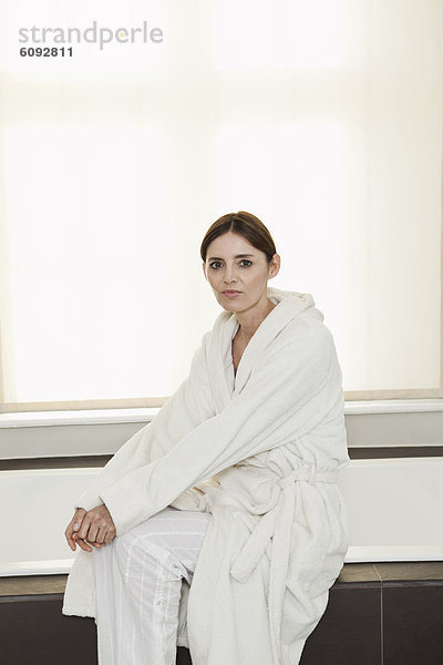 Reife Frau auf der Badewanne sitzend  Portrait