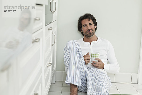 Erwachsener Mann mit Kaffeetasse in der Küche  Portrait