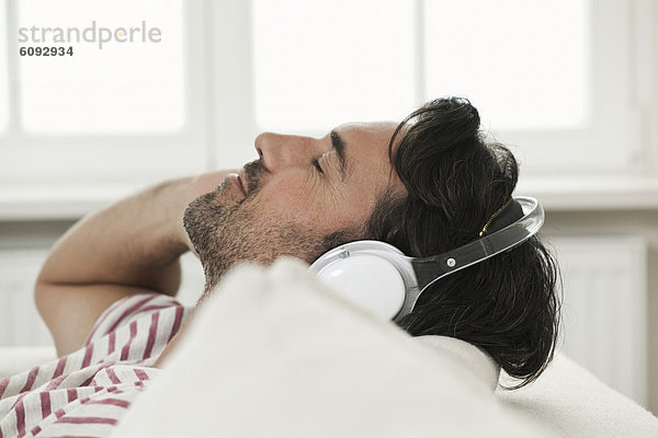 Erwachsener Mann hört Musik mit Kopfhörern