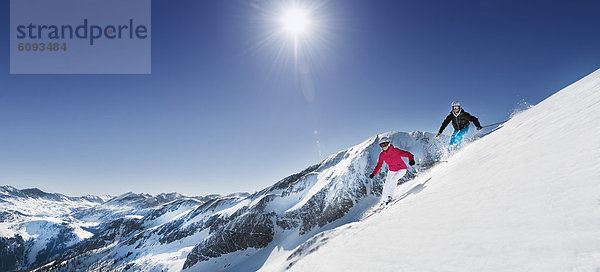 Austria  Salzburg  Young couple skiing on mountain