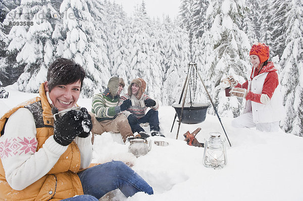 Österreich  Salzburg  Männer und Frauen am Kamin im Winter