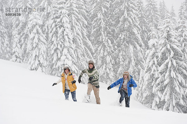 Österreich  Salzburg  Männer und Frauen beim Wandern durch die Winterlandschaft