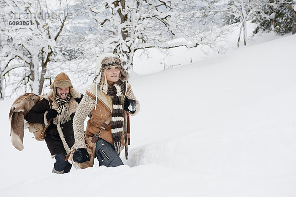 Österreich  Salzburger Land  Paar Wanderungen durch die Winterlandschaft  lächelnd