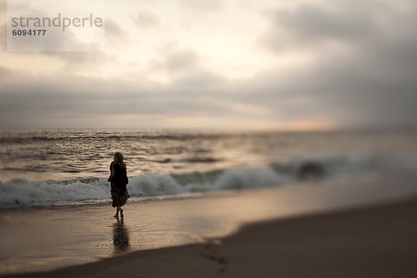 Frau gehen Strand Sonnenuntergang