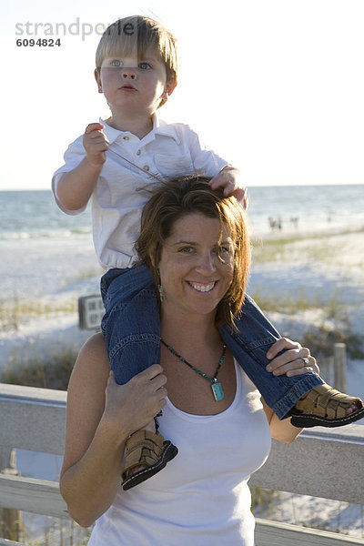 lächeln  Strand  Junge - Person  klein  Ozean  halten  Hintergrund  Menschliche Schulter  Schultern