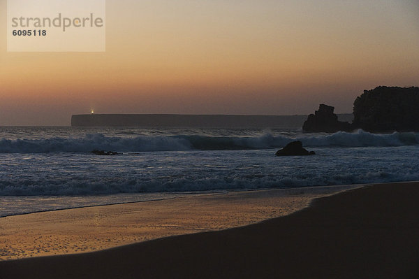 Portugal  Algarve  Sagres  Blick auf den Strand mit brechenden Wellen bei Sonnenuntergang